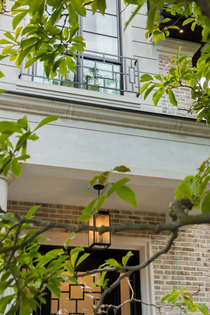 Luxury custom home exterior in Toronto featuring Indiana limestone cladding, metal canopy, and detailed façade design by Qarnis Development.