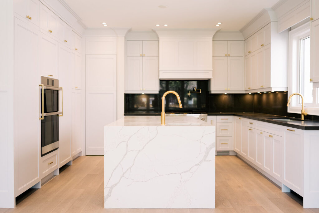 Luxury custom kitchen in Toronto with marble island, Dacor appliances, and brass accents by Qarnis Development.